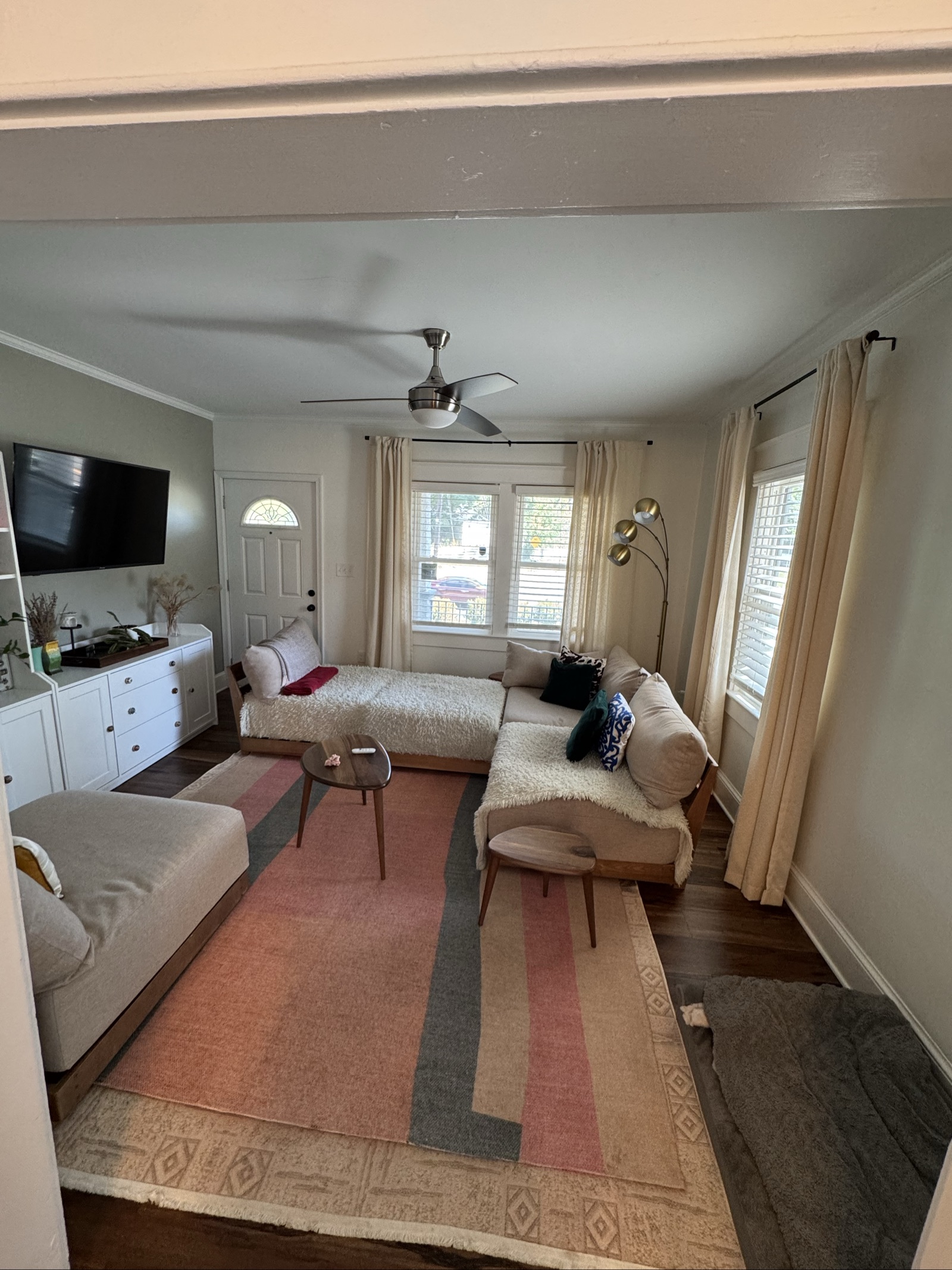Tidy living room corner with gray sofa and sunlit window